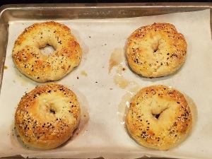 4 freshly baked bagels on pan